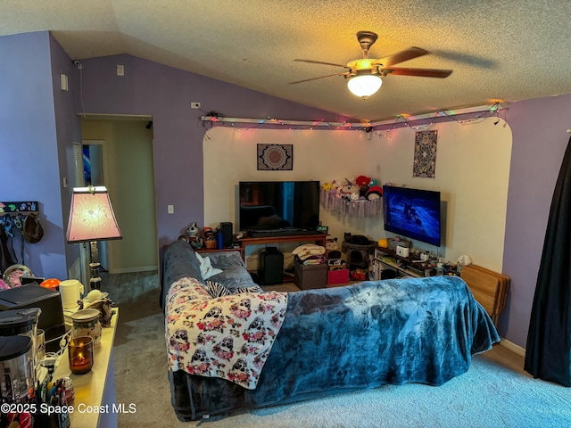 carpeted living area with a textured ceiling, ceiling fan, and vaulted ceiling