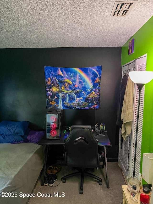 carpeted bedroom featuring visible vents and a textured ceiling