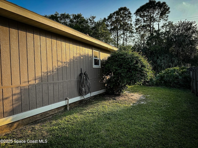 view of property exterior with a lawn and fence