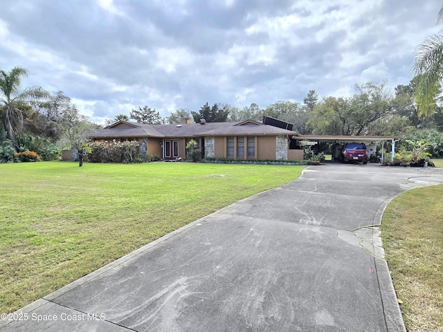 2001 Villa Espana Trl, Melbourne, FL 32935 - view of front of home featuring a front yard, driveway, a chimney, stucco siding, and a carport