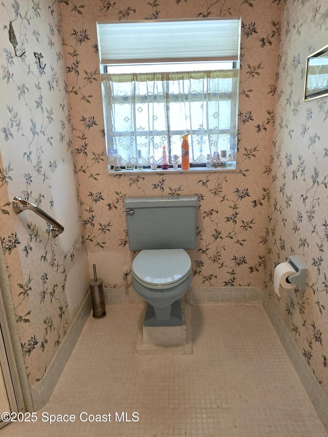 2001 Villa Espana Trl, Melbourne, FL 32935 - bathroom with wallpapered walls, tile patterned floors, toilet, and baseboards