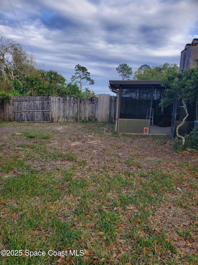 view of yard with a sunroom and fence