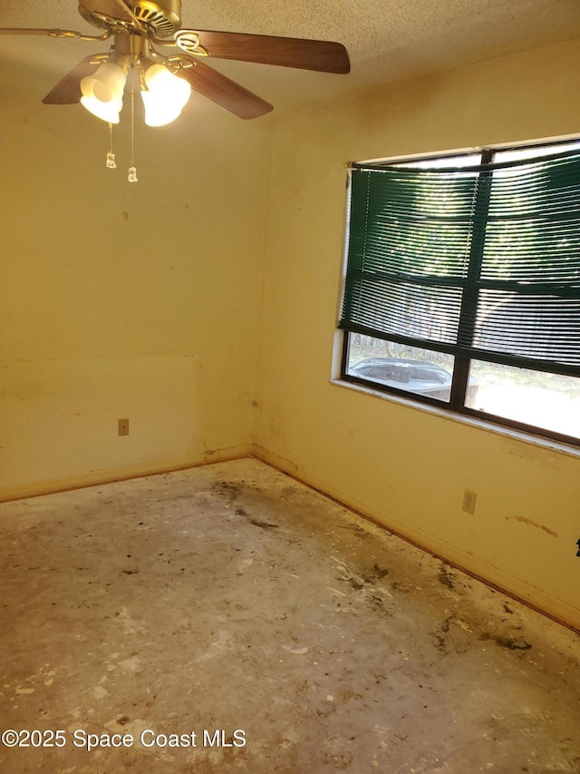 spare room with baseboards, a textured ceiling, and a ceiling fan