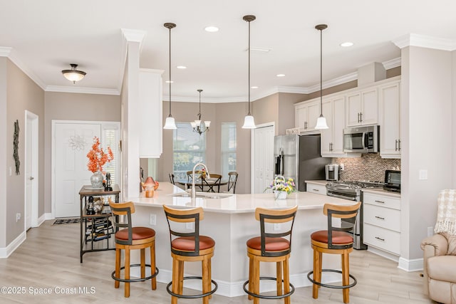 kitchen featuring a sink, white cabinets, a kitchen bar, and stainless steel appliances