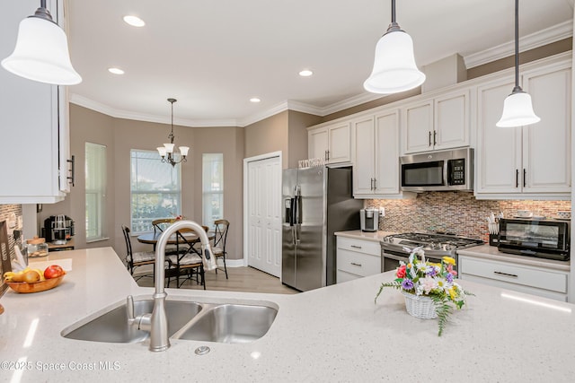 kitchen with crown molding, white cabinets, a toaster, and stainless steel appliances