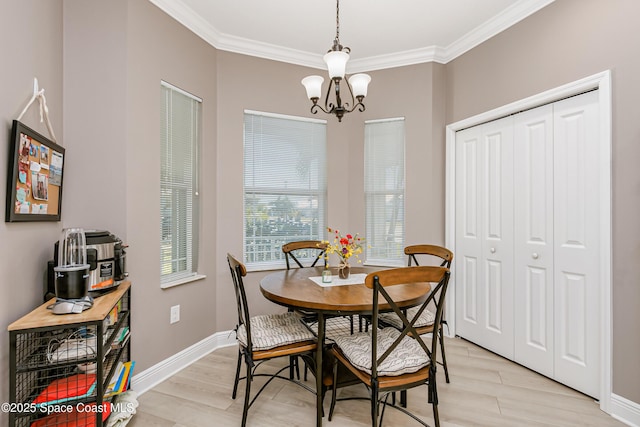 dining area with a notable chandelier, baseboards, light wood finished floors, and ornamental molding