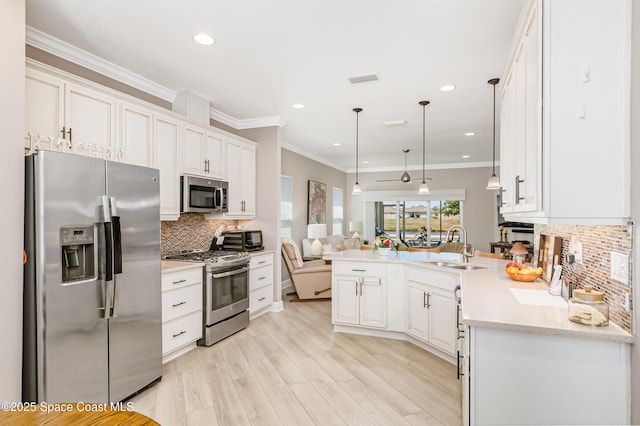 kitchen with white cabinetry, crown molding, appliances with stainless steel finishes, and a sink