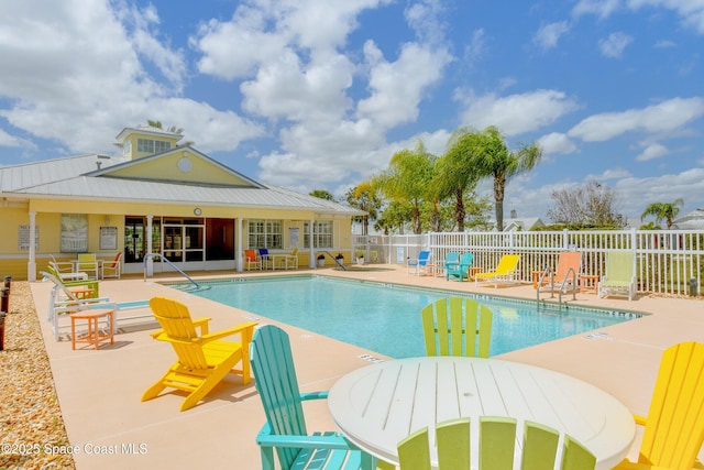 community pool with a patio and fence