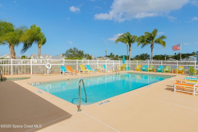 community pool with a patio and fence