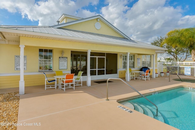 pool with a patio area and fence