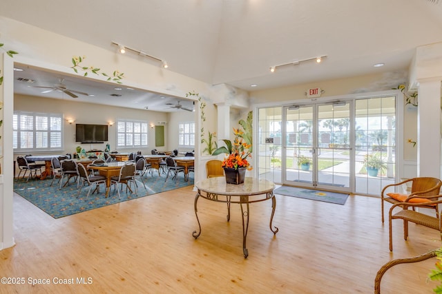 dining room with visible vents, rail lighting, wood finished floors, a ceiling fan, and ornate columns