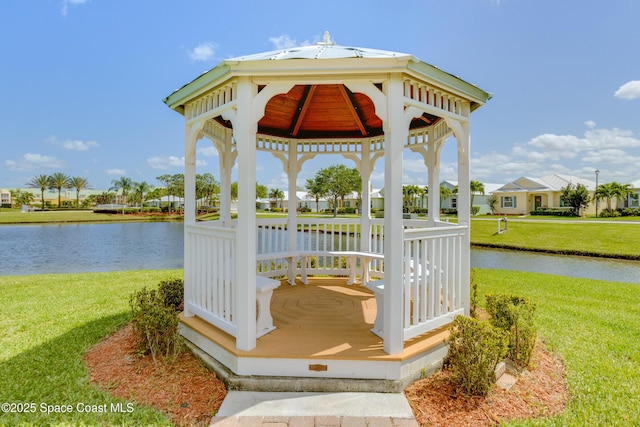 wooden terrace with a gazebo, a yard, and a water view