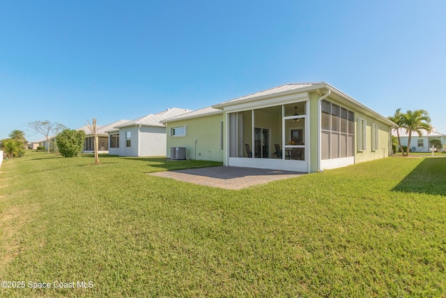 back of house with a yard, central AC unit, a sunroom, and metal roof