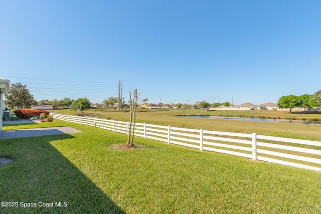 view of yard with a water view and fence