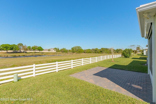 view of yard featuring a patio, a rural view, and fence