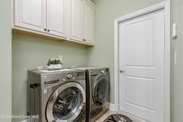 laundry room featuring washer and dryer, baseboards, and cabinet space