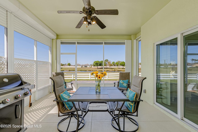 sunroom / solarium with a healthy amount of sunlight and ceiling fan