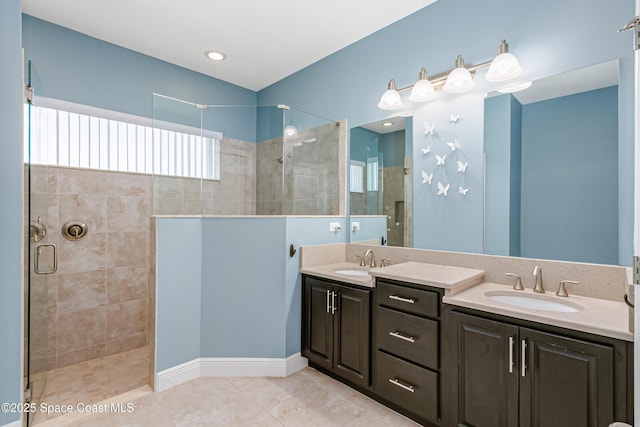 full bath with tile patterned floors, walk in shower, and a sink