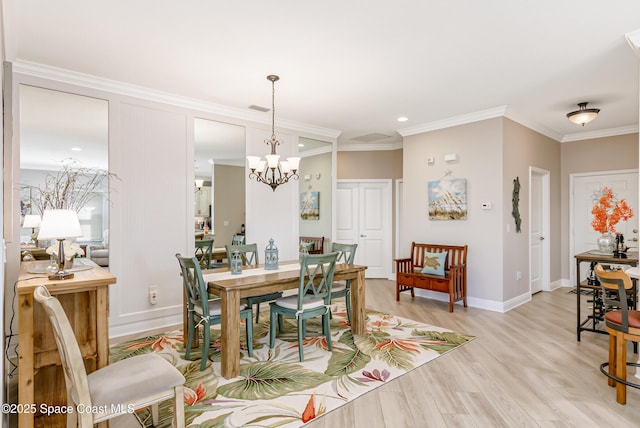 dining area featuring visible vents, crown molding, baseboards, light wood-style floors, and a notable chandelier