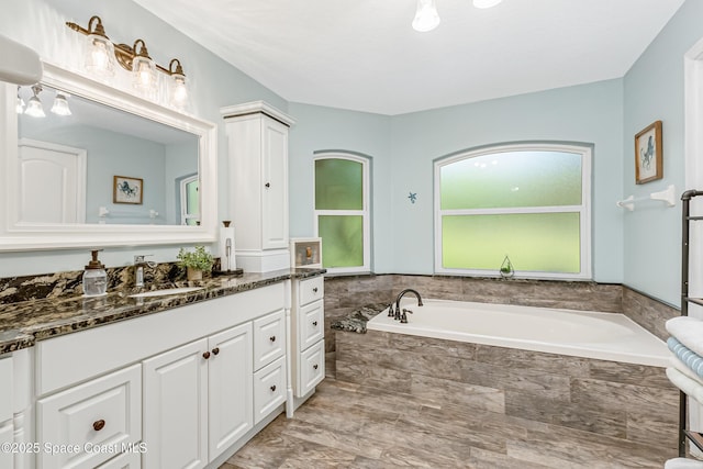 bathroom with vanity and a garden tub