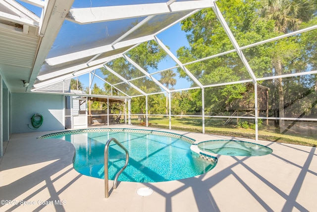 view of pool featuring glass enclosure, a patio area, and a pool with connected hot tub