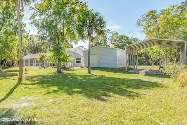 view of yard with a detached carport, an outbuilding, and a garage