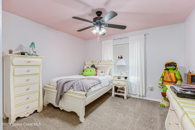 bedroom featuring light colored carpet, baseboards, and a ceiling fan