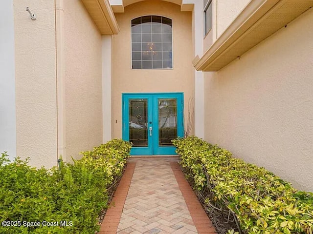 entrance to property featuring stucco siding and french doors