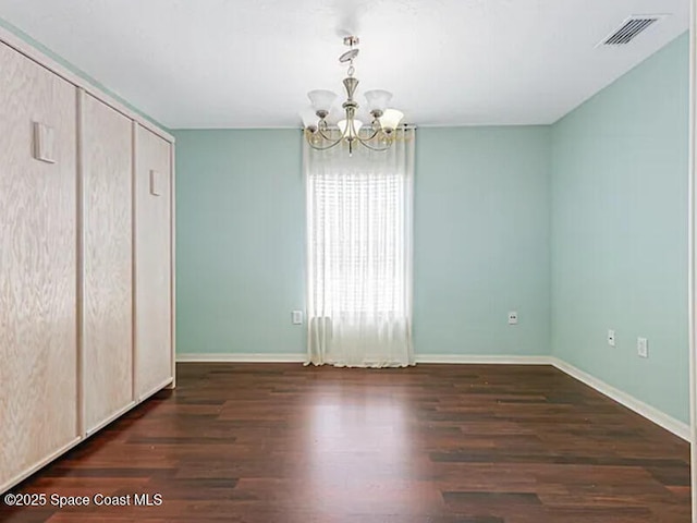 interior space featuring a notable chandelier, visible vents, baseboards, and wood finished floors