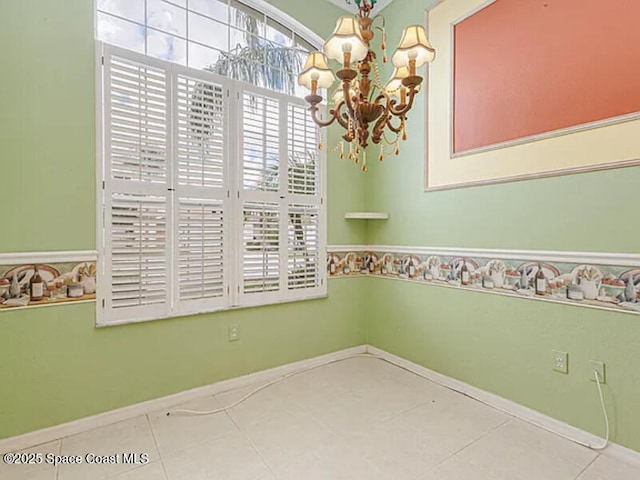 tiled empty room with a notable chandelier