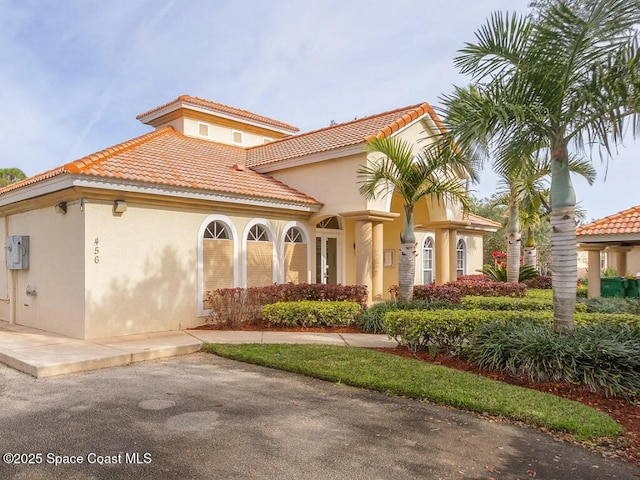 mediterranean / spanish home with stucco siding and a tile roof