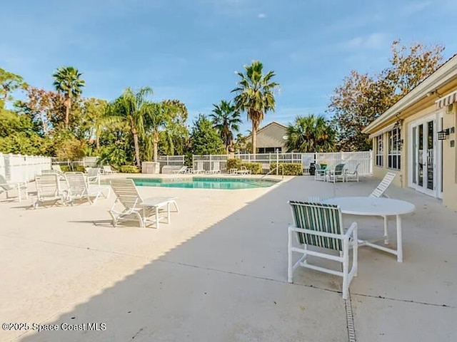 pool with french doors, a patio, and fence