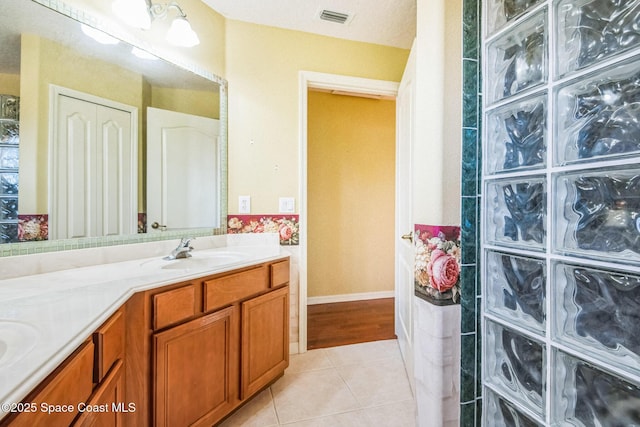 full bathroom with tile patterned floors, visible vents, double vanity, and a sink