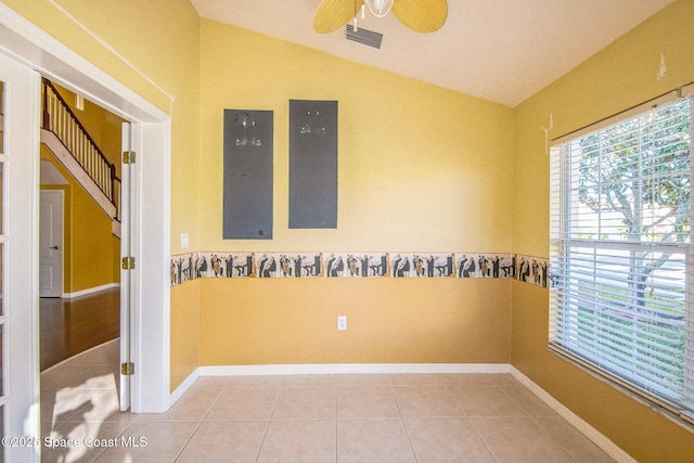 spare room featuring light tile patterned floors, ceiling fan, baseboards, and lofted ceiling