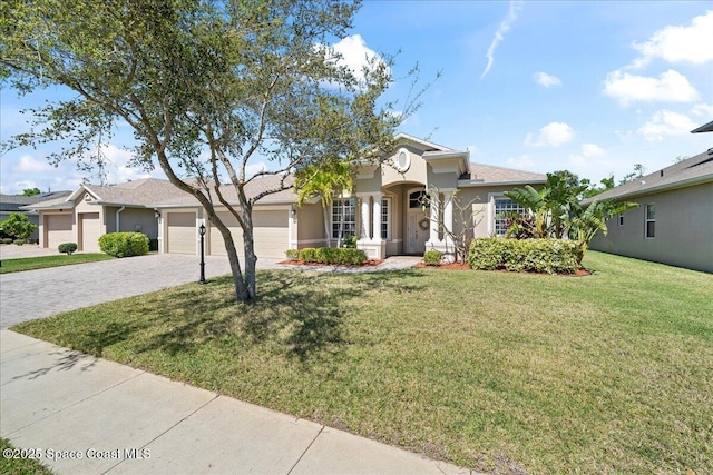 view of front of house with decorative driveway, a front yard, an attached garage, and stucco siding