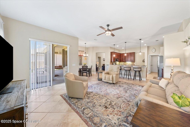 living area with light tile patterned floors, ceiling fan with notable chandelier, recessed lighting, and baseboards