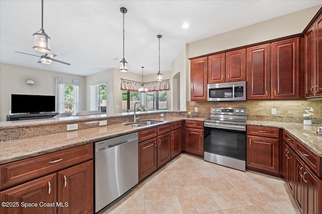 kitchen featuring a sink, stainless steel appliances, decorative light fixtures, and decorative backsplash