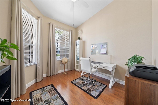 office with light wood-style flooring, a ceiling fan, and baseboards