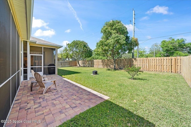 view of yard featuring a patio area, a fenced backyard, and a sunroom