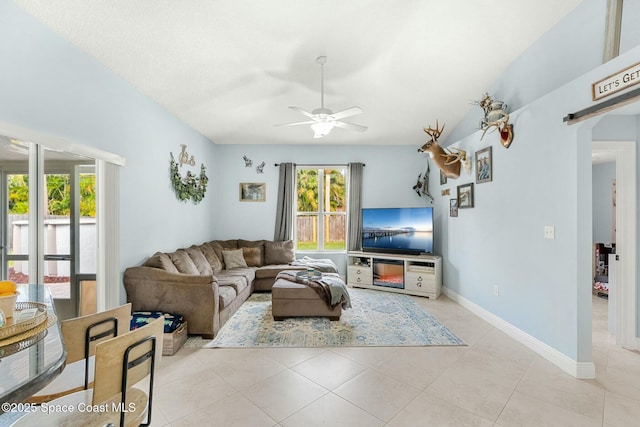 living area with tile patterned flooring, a ceiling fan, and baseboards