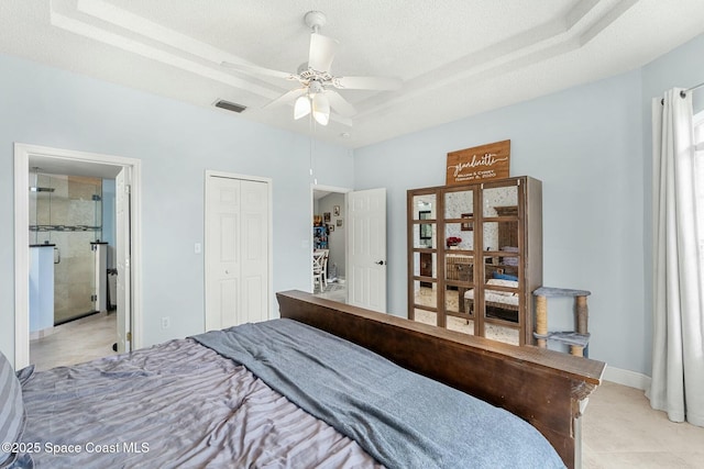 bedroom featuring a tray ceiling, light tile patterned floors, baseboards, and visible vents