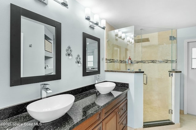 full bath featuring a sink, double vanity, and a shower stall