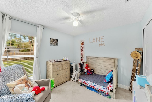 bedroom featuring tile patterned floors, baseboards, a textured ceiling, and ceiling fan