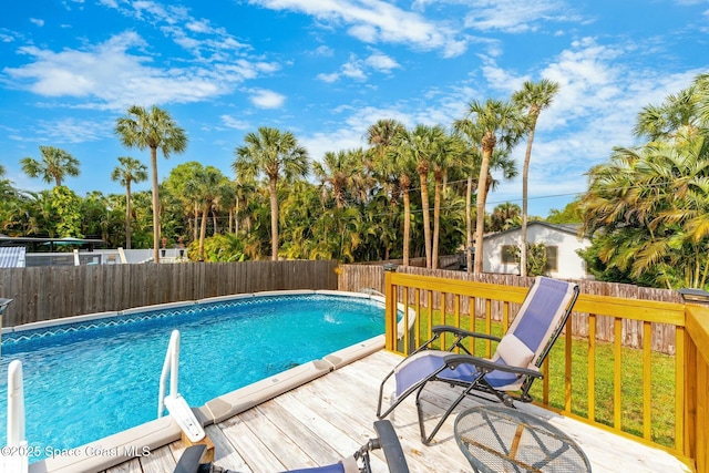 view of pool featuring a wooden deck, a fenced in pool, a lawn, and a fenced backyard