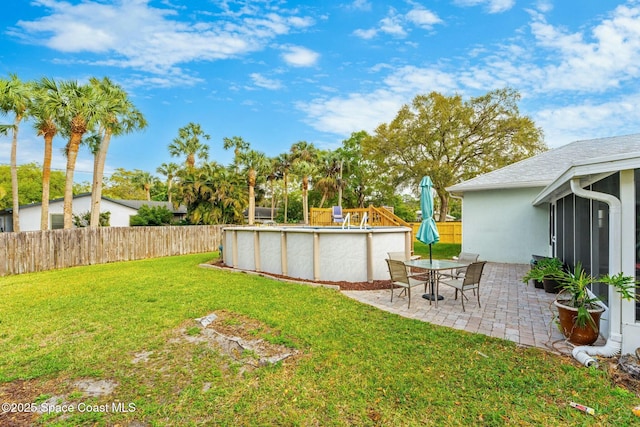 view of yard featuring a patio, fence, and a fenced in pool