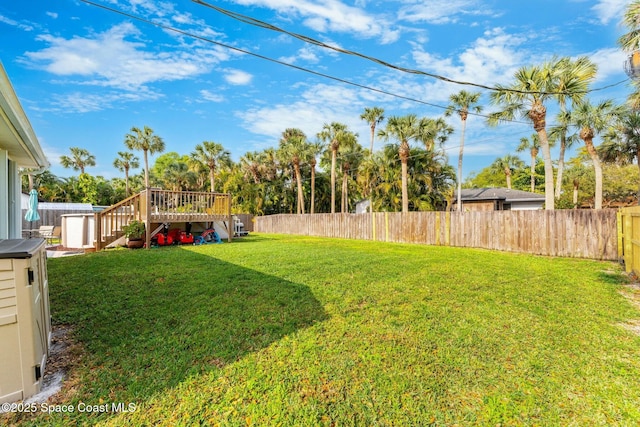 view of yard featuring stairway, a wooden deck, and a fenced backyard