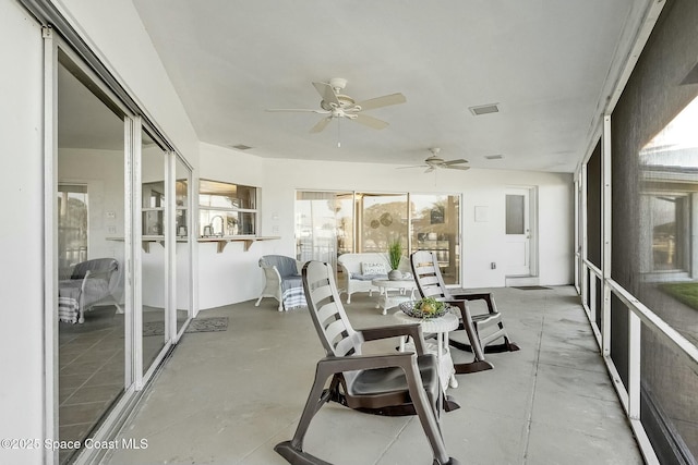 sunroom / solarium with visible vents and ceiling fan