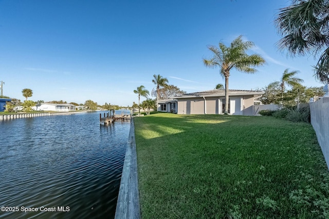 view of dock featuring a lawn, a water view, and fence