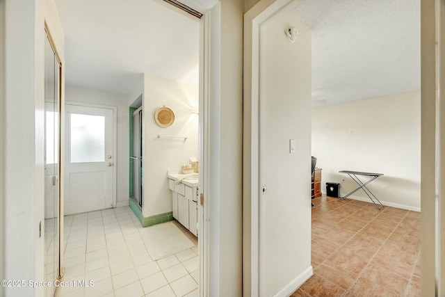 corridor with light tile patterned floors and baseboards