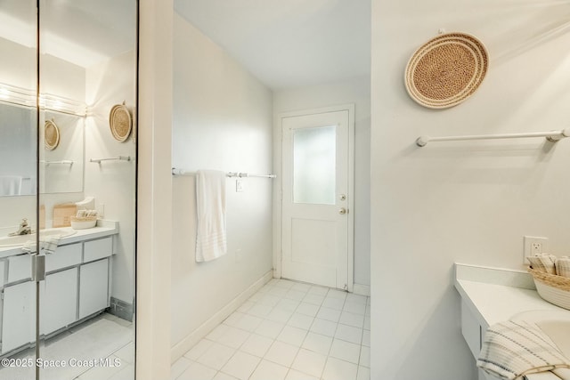 full bath with baseboards, vanity, and tile patterned flooring